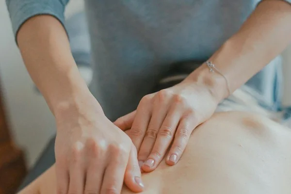 Practitioner's hands working on a patient's back