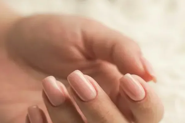Hand with a soft pink gel manicure